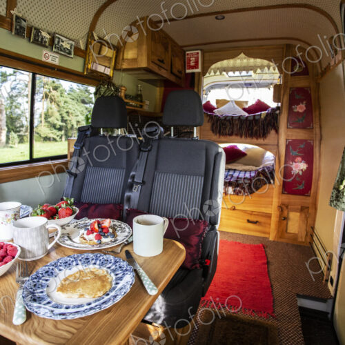 Interior view of camper van with breakfast on table. Interior view of camper van with breakfast on table.