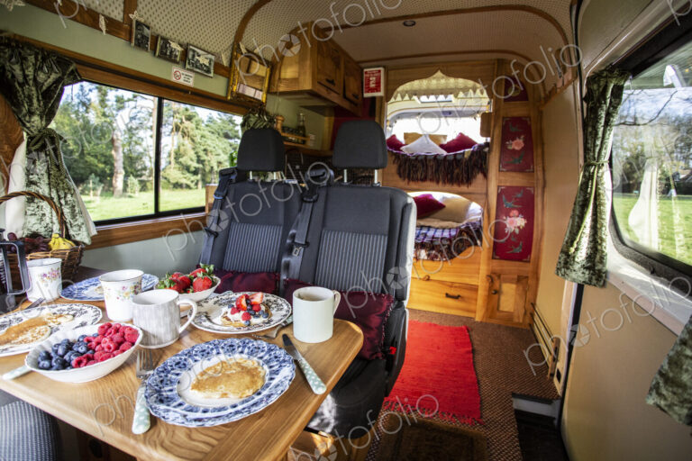 Interior view of camper van with breakfast on table.