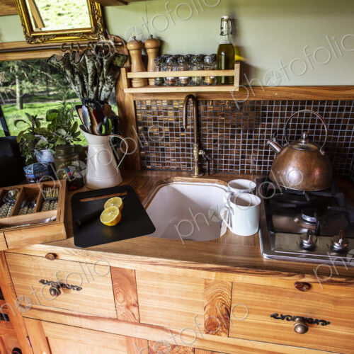 Interior view of camper van with small cooking area and sink. Interior view of camper van with small cooking area and sink.