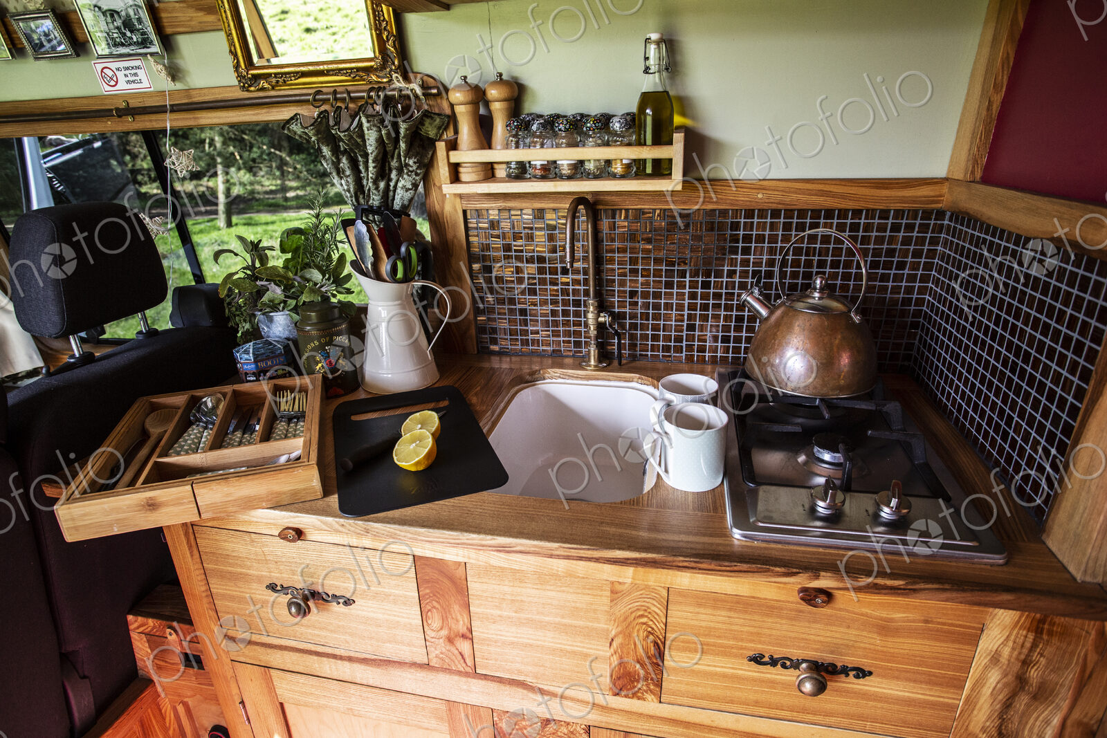 Interior view of camper van with small cooking area and sink.