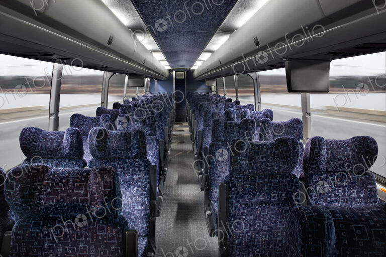Interior view of passenger seating in a bus, in rows.