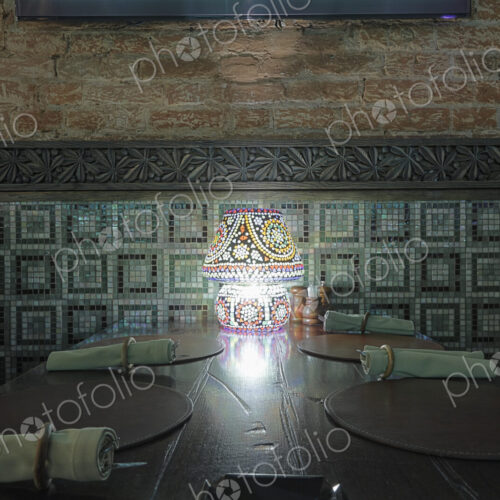 Interior view of restaurant with lamp on table.