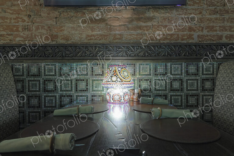 Interior view of restaurant with lamp on table.
