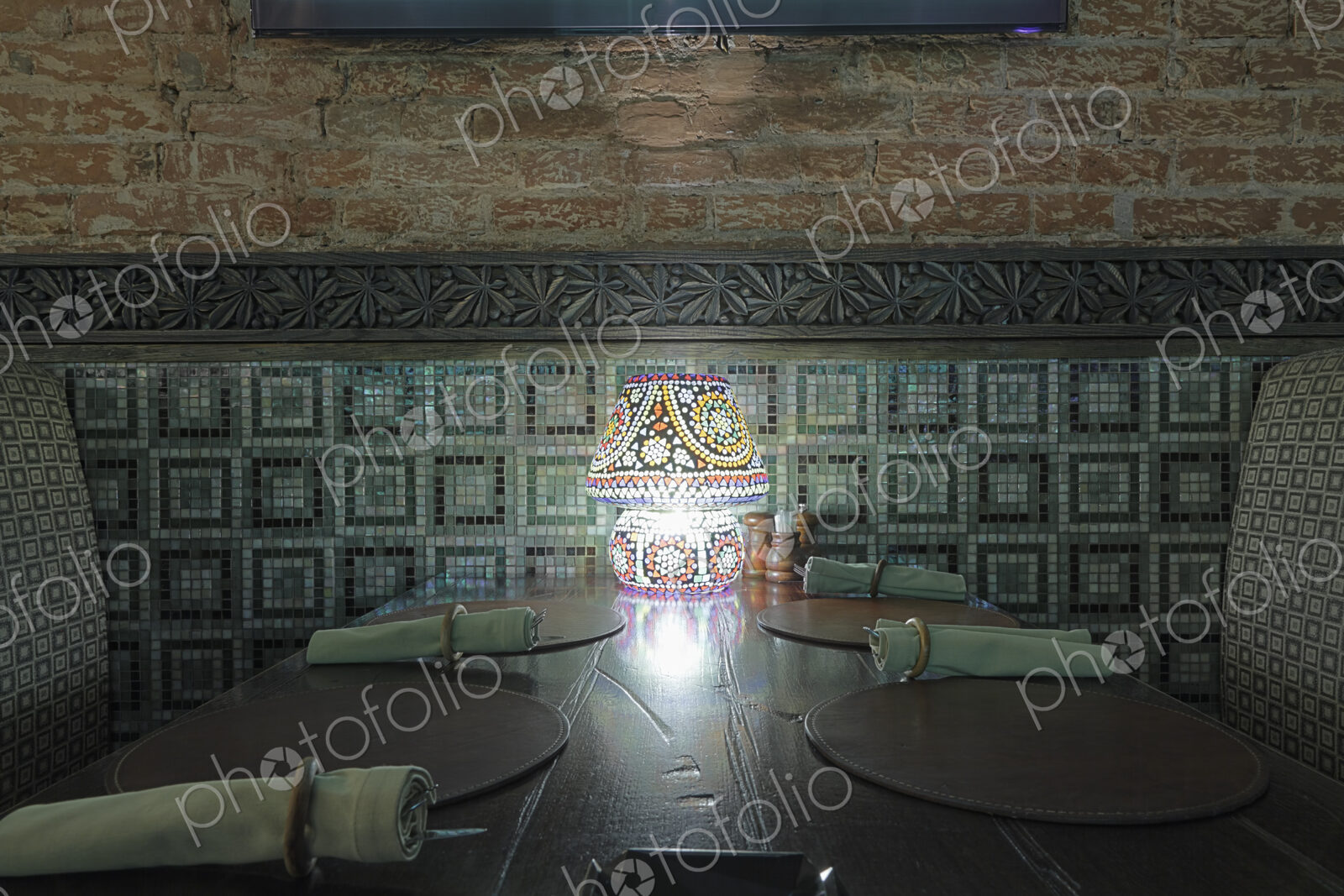 Interior view of restaurant with lamp on table.