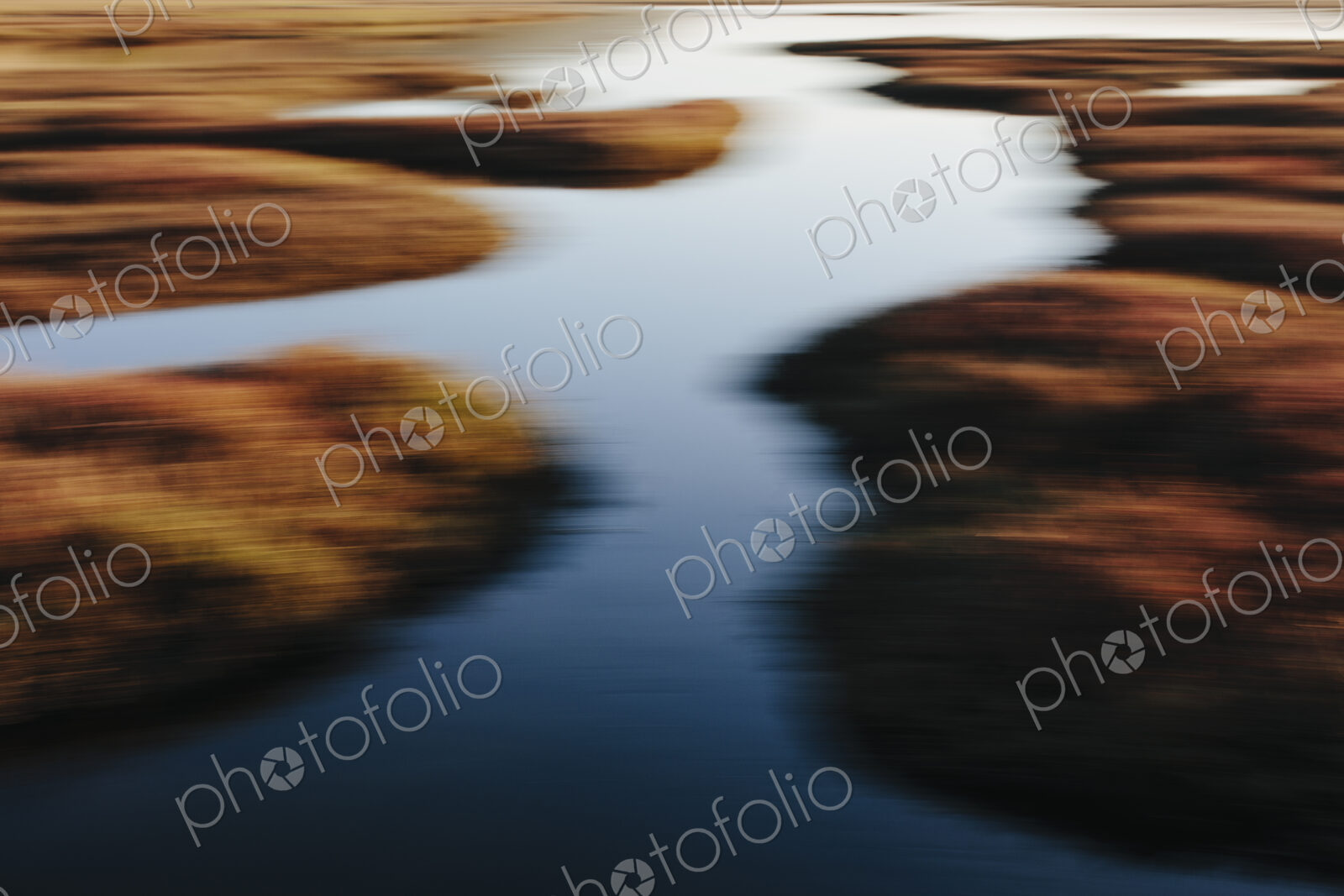 Intertidal estuary with water channels at dusk