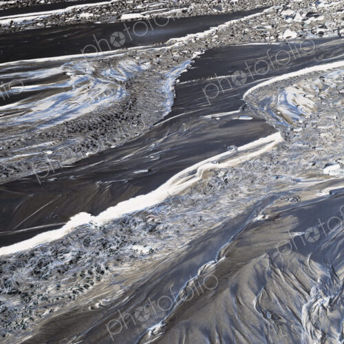 Inverted abstract image of small intertidal stream on beach, sand and water patterns Inverted abstract image of small intertidal stream on beach, sand and water patterns