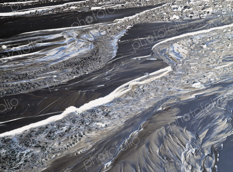 Inverted abstract image of small intertidal stream on beach, sand and water patterns
