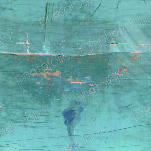 Inverted image of scratch marks and peeling blue paint on metal wall
