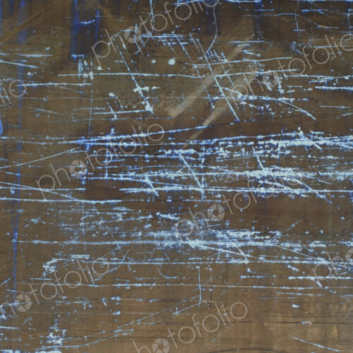 Inverted image of scratch marks and peeling paint on metal wall