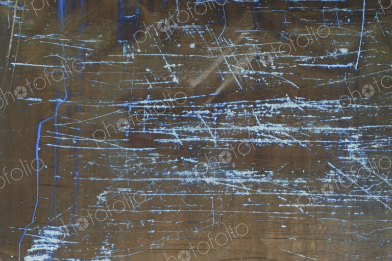 Inverted image of scratch marks and peeling paint on metal wall