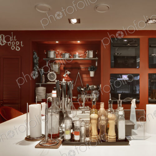 Italian themed kitchen with island covered in condiments and seasonings.