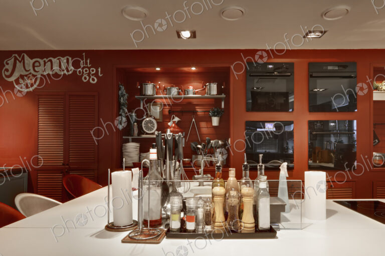 Italian themed kitchen with island covered in condiments and seasonings.
