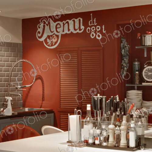Italian themed kitchen with island covered in condiments and seasonings.