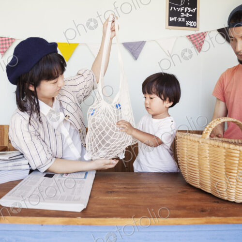 Japanese man, woman and boy standing in a farm shop, sorting clear plastic bottles…