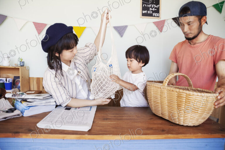 Japanese man, woman and boy standing in a farm shop, sorting clear plastic bottles…