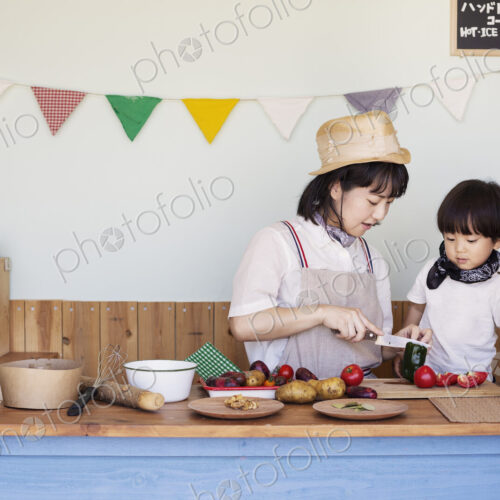 Japanese woman and boy standing in a farm shop, preparing food.