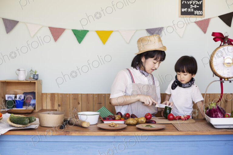 Japanese woman and boy standing in a farm shop, preparing food.