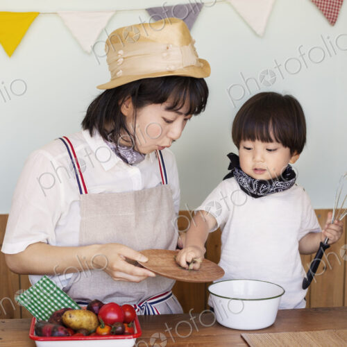 Japanese woman and boy standing in a farm shop, preparing food. Japanese woman and boy standing in a farm shop, preparing food.