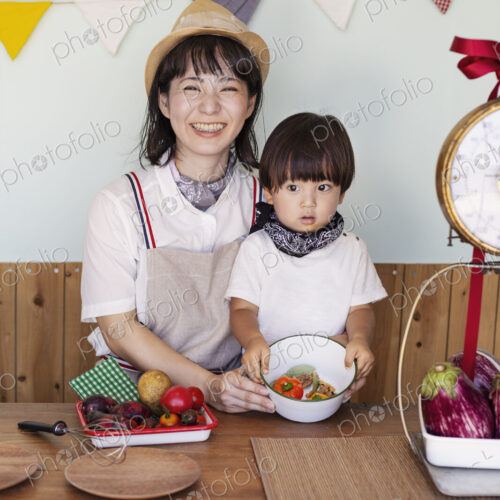 Japanese woman and boy standing in a farm shop, preparing food. Japanese woman and boy standing in a farm shop, preparing food.
