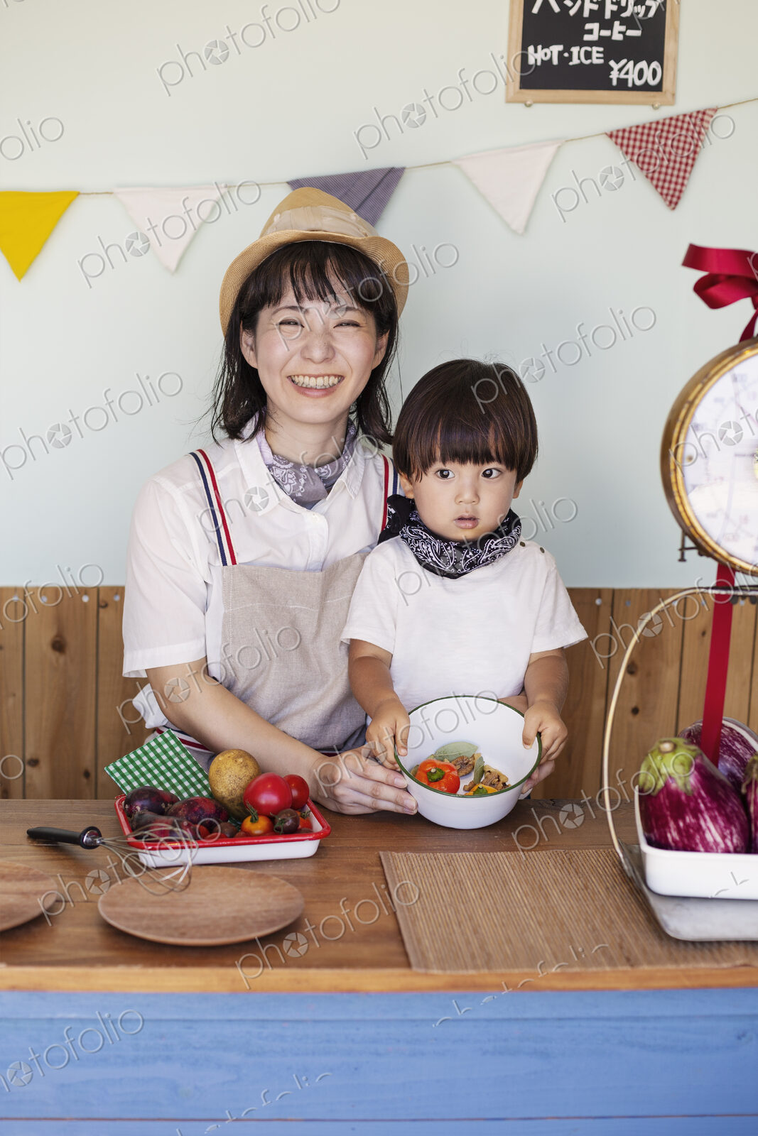 Japanese woman and boy standing in a farm shop, preparing food.