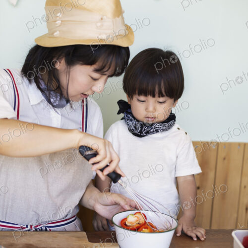 Japanese woman and boy standing in a farm shop, preparing food. Japanese woman and boy standing in a farm shop, preparing food.