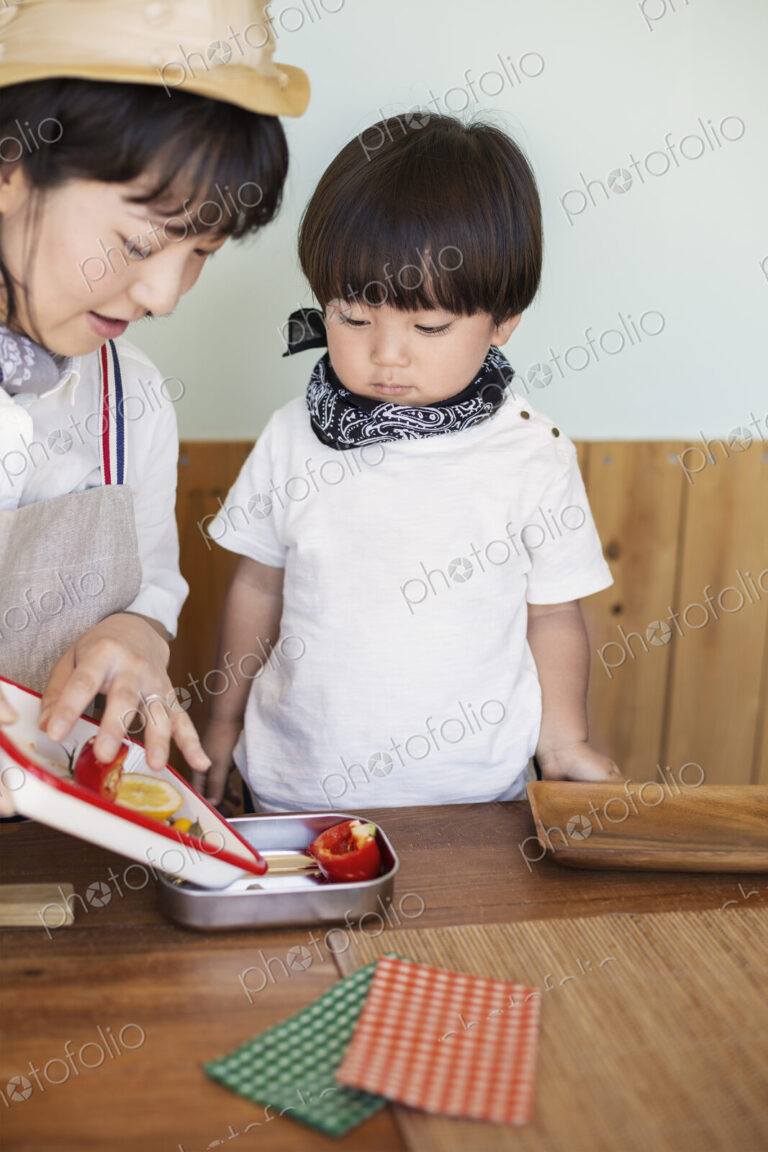 Japanese woman and boy standing in a farm shop, preparing food.