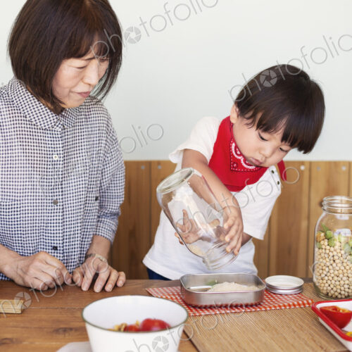 Japanese woman and boy standing in a farm shop, preparing food.