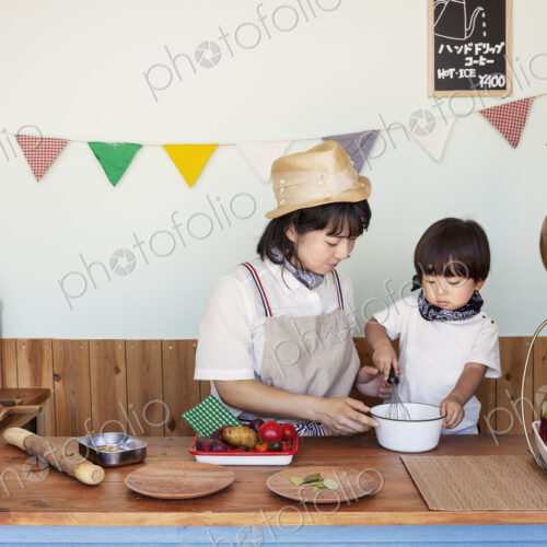 Japanese woman and boy standing in a farm shop, preparing food.