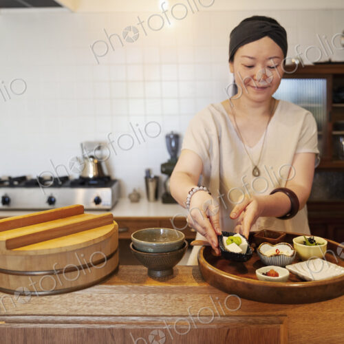 Japanese woman preparing food in a vegetarian cafe. Japanese woman preparing food in a vegetarian cafe.