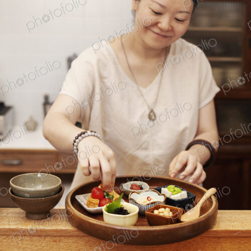 Japanese woman preparing fresh vegetables in a vegetarian cafe. Japanese woman preparing fresh vegetables in a vegetarian cafe.