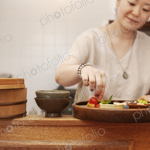 Japanese woman preparing fresh vegetables in a vegetarian cafe. Japanese woman preparing fresh vegetables in a vegetarian cafe.
