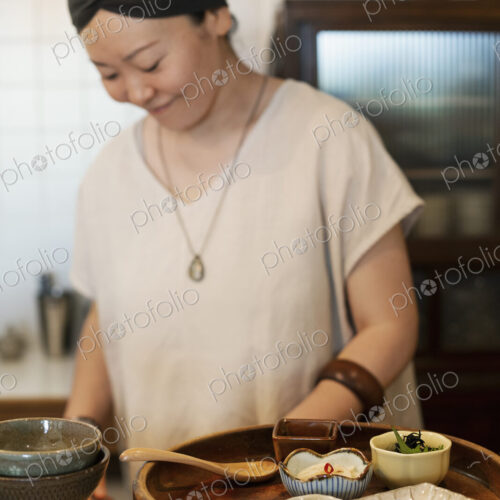 Japanese woman preparing fresh vegetables in a vegetarian cafe. Japanese woman preparing fresh vegetables in a vegetarian cafe.