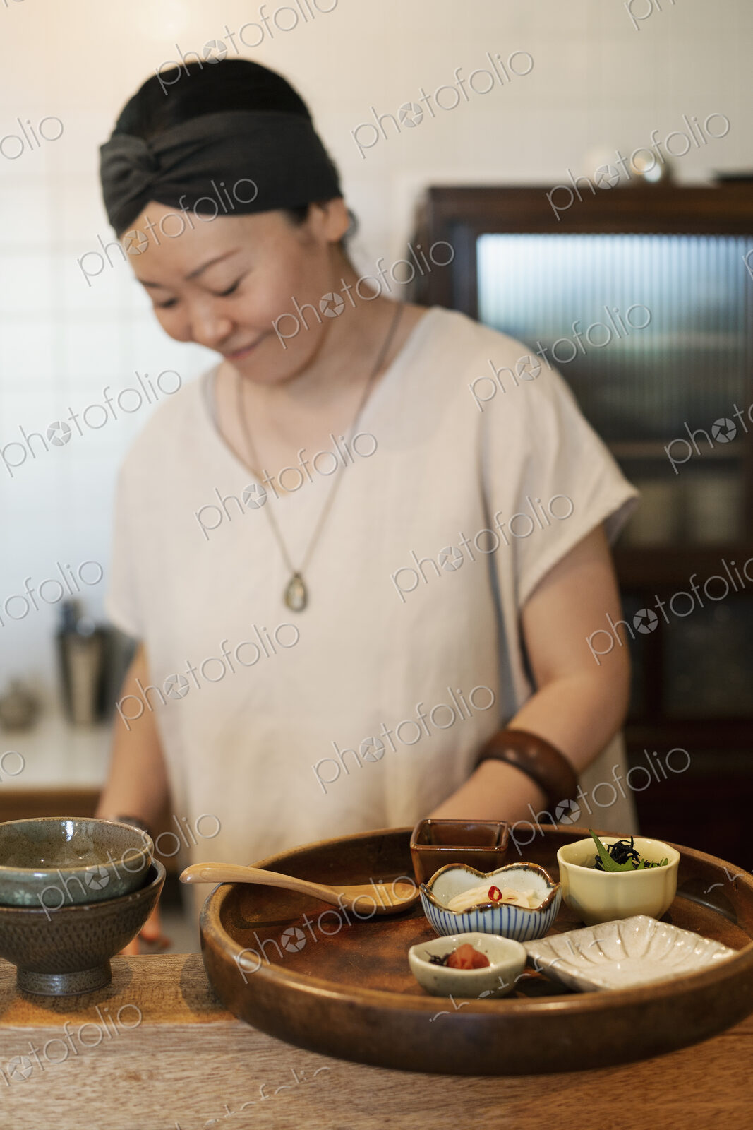 Japanese woman preparing fresh vegetables in a vegetarian cafe.