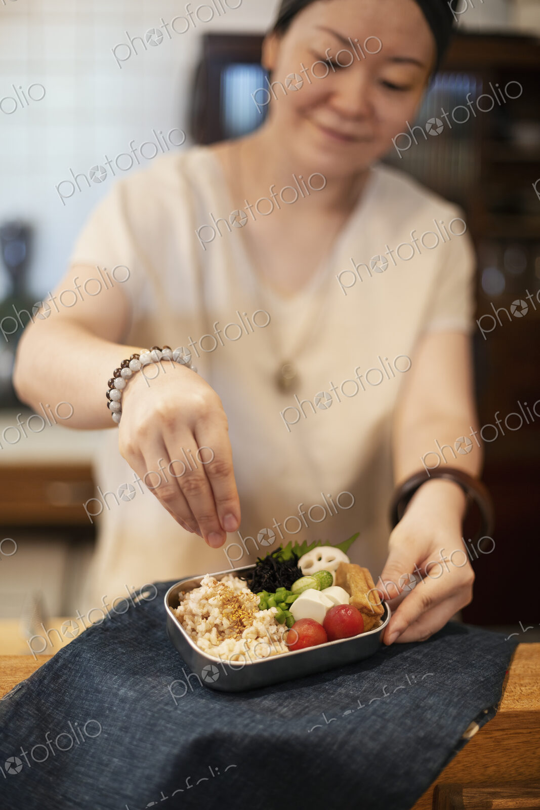 Japanese woman preparing fresh vegetables in a vegetarian cafe.