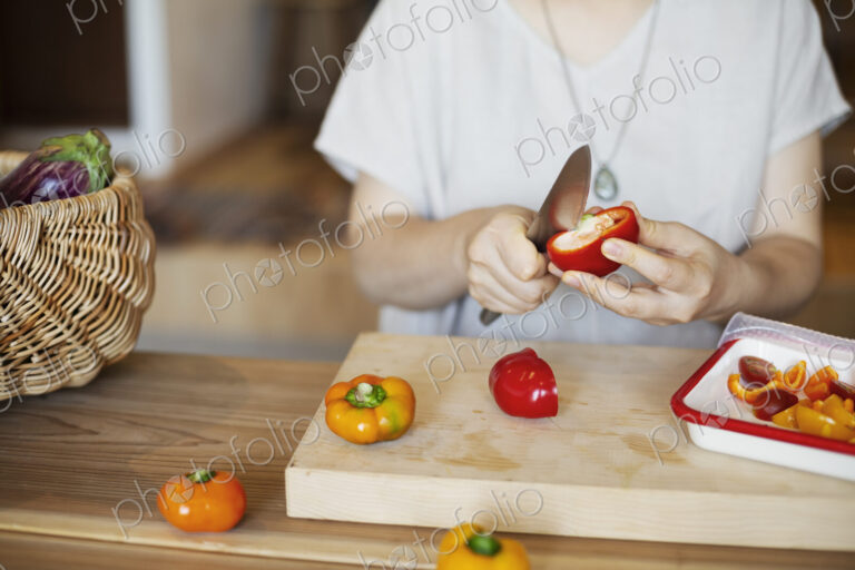 Japanese woman preparing fresh vegetables in a vegetarian cafe.