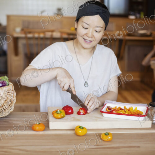 Japanese woman preparing fresh vegetables in a vegetarian cafe. Japanese woman preparing fresh vegetables in a vegetarian cafe.