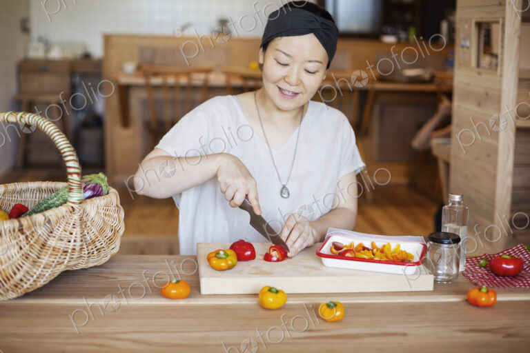 Japanese woman preparing fresh vegetables in a vegetarian cafe.