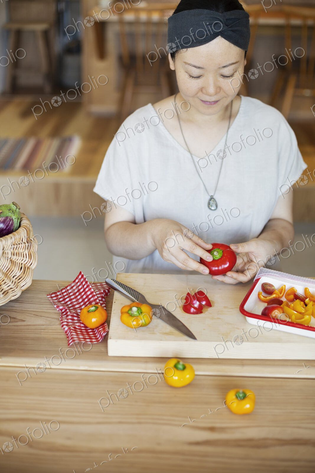 Japanese woman preparing fresh vegetables in a vegetarian cafe.