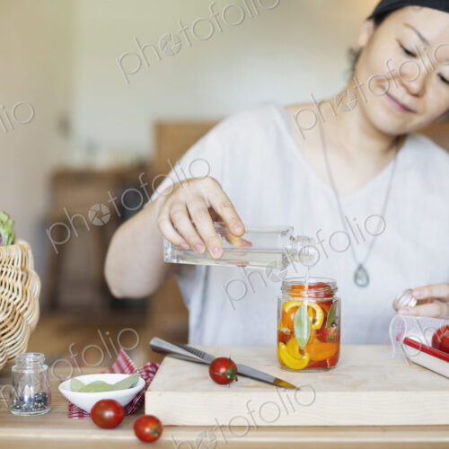 Japanese woman preparing fresh vegetables in a vegetarian cafe. Japanese woman preparing fresh vegetables in a vegetarian cafe.