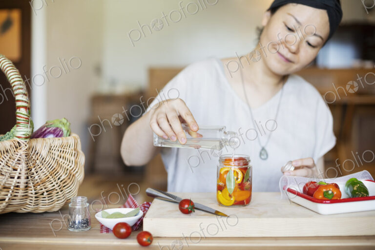 Japanese woman preparing fresh vegetables in a vegetarian cafe.