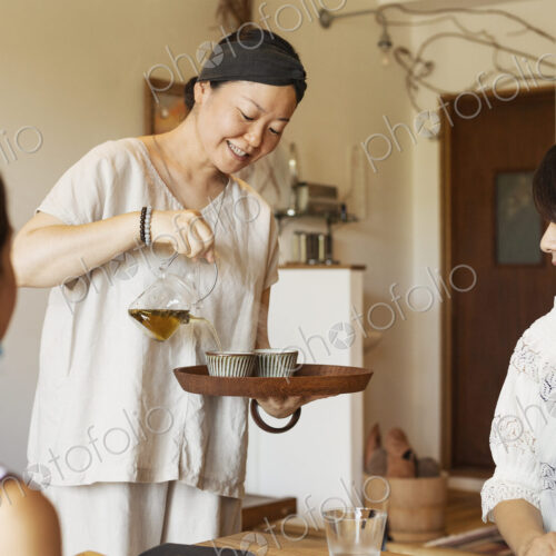 Japanese woman serving two female customers in a vegetarian cafe. Japanese woman serving two female customers in a vegetarian cafe.