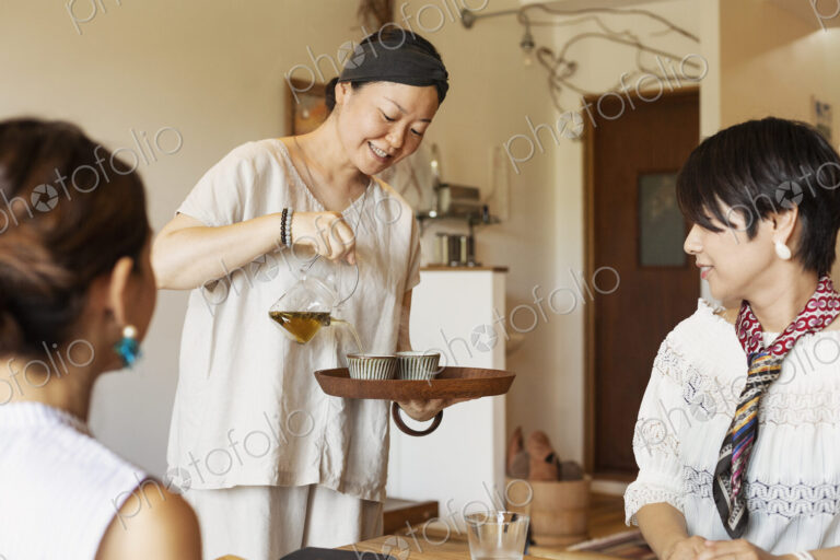 Japanese woman serving two female customers in a vegetarian cafe.