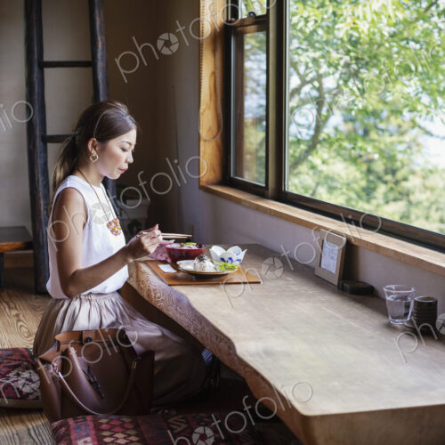 Japanese woman sitting at a table in a Japanese restaurant, eating. Japanese woman sitting at a table in a Japanese restaurant, eating.