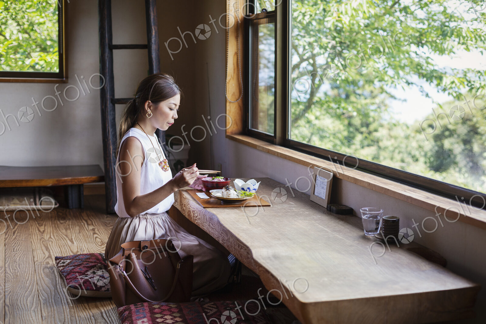 Japanese woman sitting at a table in a Japanese restaurant, eating.