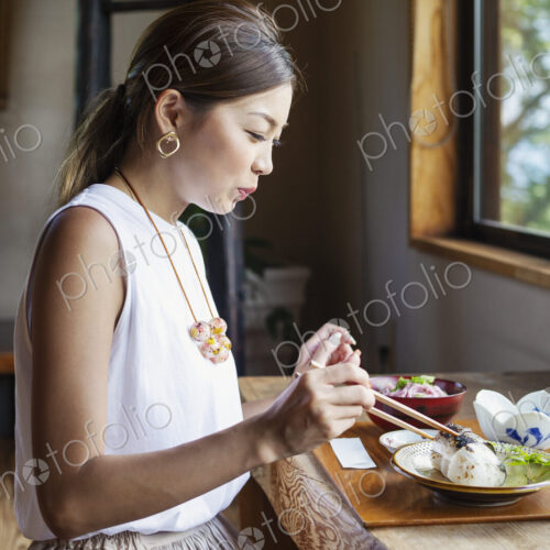 Japanese woman sitting at a table in a Japanese restaurant, eating. Japanese woman sitting at a table in a Japanese restaurant, eating.