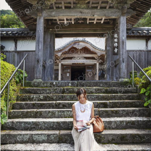Japanese woman sitting on steps outside a Buddhist temple. Japanese woman sitting on steps outside a Buddhist temple.