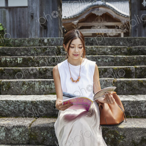 Japanese woman sitting on steps outside a Buddhist temple. Japanese woman sitting on steps outside a Buddhist temple.