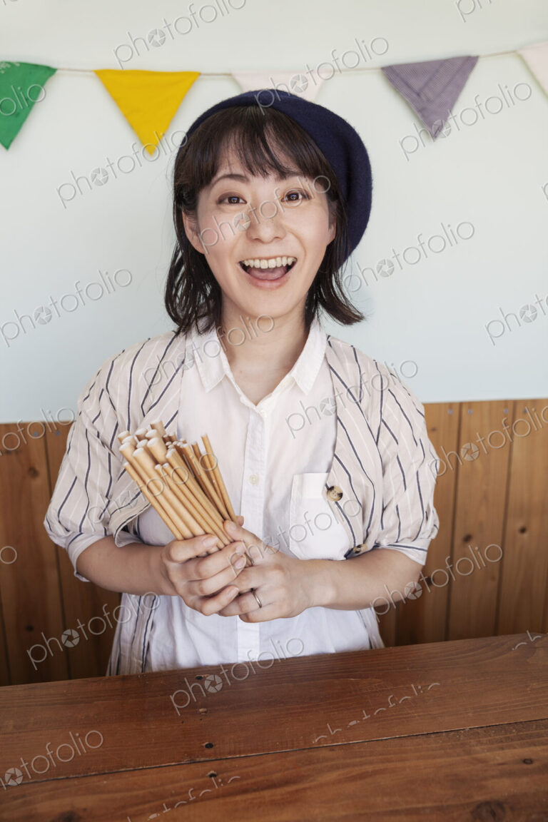 Japanese woman standing behind counter in a farm shop, smiling at camera.