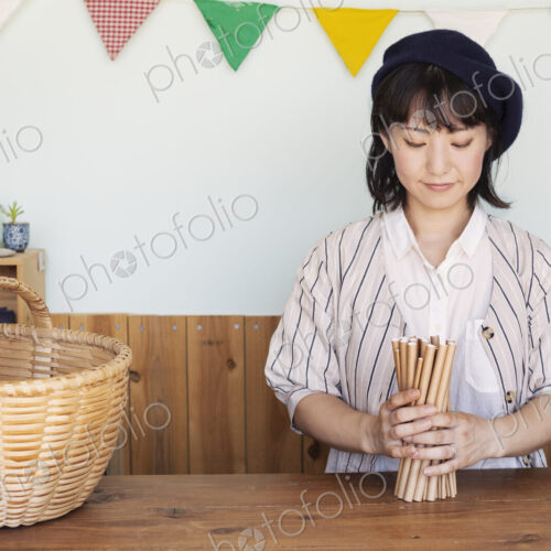 Japanese woman standing next to a basket behind counter in a farm shop. Japanese woman standing next to a basket behind counter in a farm shop.