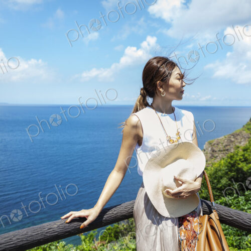 Japanese woman standing on a cliff,ocean in the background. Japanese woman standing on a cliff,ocean in the background.